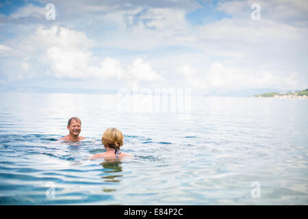 Senior couple profitant de la retraite sur un mi-ombre, se baigne dans la mer, riant ensemble, rester actif et positif Banque D'Images