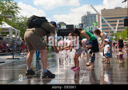 Les parents et les enfants appréciant les fontaines sur la Place des Festivals, Montréal, province de Québec, Canada. Banque D'Images