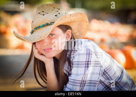 Jolie Preteen Girl Wearing Cowboy Hat Portrait à la citrouille dans un cadre rustique. Banque D'Images