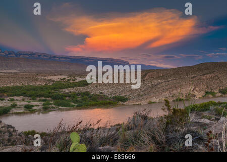 Coucher du soleil se reflétant dans le fleuve Rio Grande à Boquillas Canyon avec en toile de fond la montagne de Sierra del Carmen au Mexique. Banque D'Images