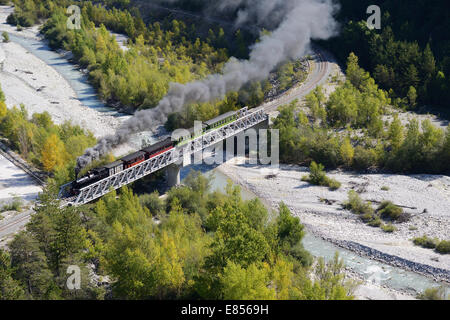 VUE AÉRIENNE.Train à vapeur historique et touristique sur un pont à tréteaux au-dessus de la rivière Var.Train des Pignes entre Entrouvaux et Annot, France. Banque D'Images