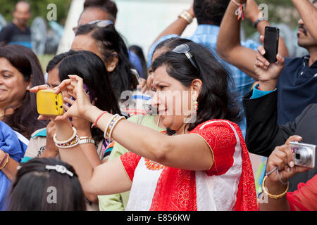 Femme indienne l'enregistrement vidéo d'un événement à l'aide de smart phone - USA Banque D'Images