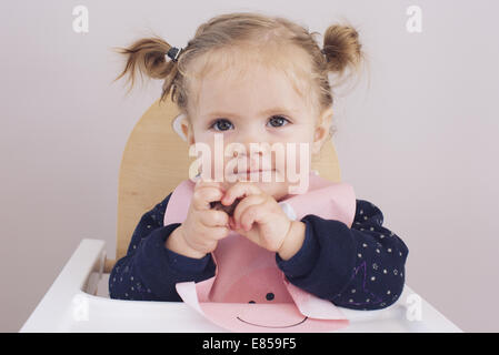 Baby Girl sitting in high chair, portrait Banque D'Images