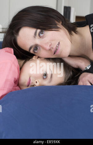 Mère et fille lying together on bed, portrait Banque D'Images
