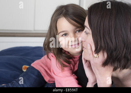 Petite fille embrassant sa mère et smiling Banque D'Images