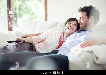 Couple watching TV ensemble sur canapé Banque D'Images