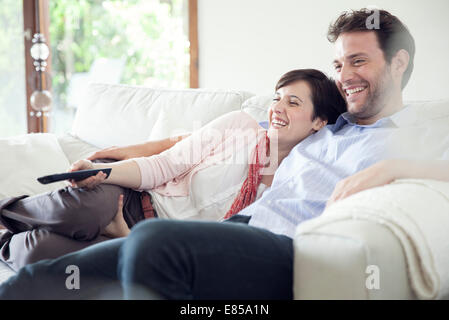 Couple watching TV ensemble sur canapé Banque D'Images