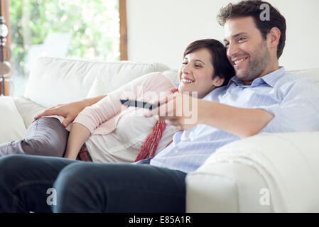 Couple watching TV ensemble sur canapé Banque D'Images