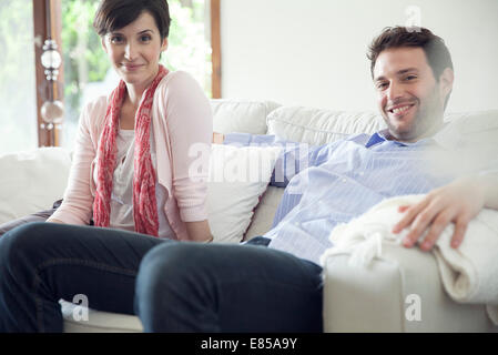 Couple relaxing on sofa at home Banque D'Images