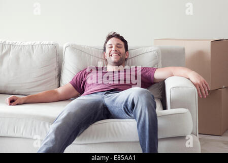 Man relaxing on sofa alors que d'un déménagement Banque D'Images