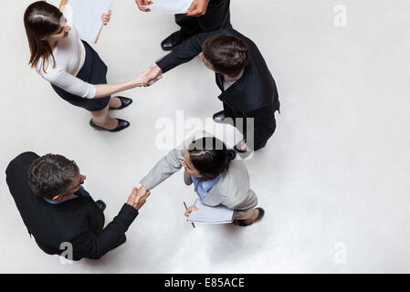 Des collègues de se serrer la main, overhead view Banque D'Images