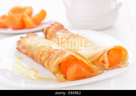 Crêpes avec tranches d'abricots on white plate Banque D'Images