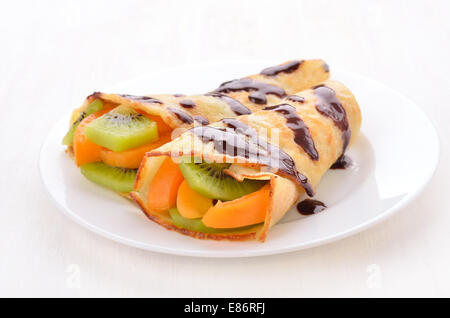 Crêpes avec kiwi et tranches d'abricots on white plate Banque D'Images