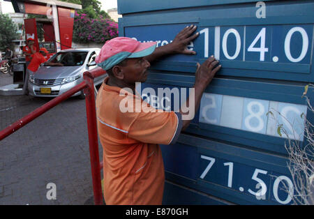 L'évolution de l'employé de la pompe à carburant le prix du carburant diminue après que les prix sur les produits pétroliers, à Karachi le mercredi, Octobre 01, 2014. Pakistan : le gouvernement fédéral a approuvé jusqu'à Rs2.95 par litre couper dans le prix des produits pétroliers (POL) du 1 octobre de porter assistance aux consommateurs. Le nouveau prix de l'essence sera Rs103.62 après une réduction de la rs2.94 ; High Octane Composante mixte (HOBC) sera fixé à Rs131.13, une réduction de la rs1.88 ; huile de kérosène sera fixé à Rs95.60 après une coupure de Rs1.31 ; diesel à haute vitesse sera fixé à Rs107.39, Banque D'Images