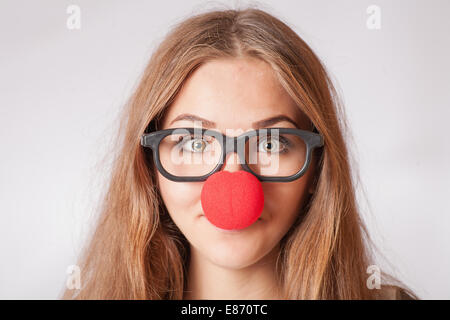 Close-up portrait of a happy 20s girl with red clown nose Banque D'Images