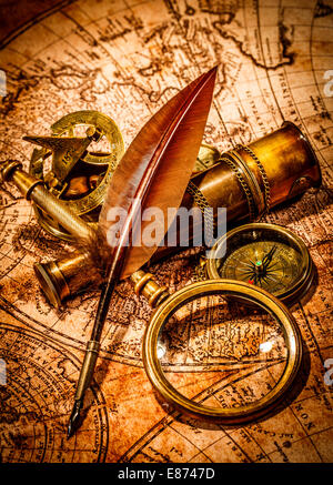 Vintage loupe, boussole, plume d'oie et spyglass allongé sur une vieille carte. Banque D'Images