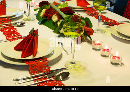 Table de Noël décorée avec des serviettes rouges et arrangement floral Banque D'Images