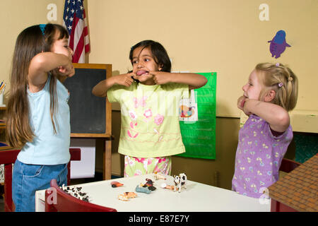 Diversité ethnique making faces 4-5 ans ans pre-k groupe racial de la maternelle Multi in classe MR © Myrleen Pearson Banque D'Images