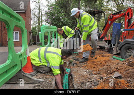 Installer de nouveaux ouvriers pour les câbles à fibre optique à large bande haute vitesse dans une rue rurale dans le sud de l'Angleterre Banque D'Images