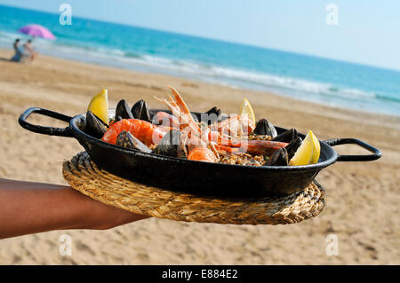 Une paella espagnole typique avec des fruits de mer dans une paellera, la paella pan, sur la plage Banque D'Images