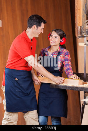 Carpenter à la collègue à pendant la mesure de plank Banque D'Images