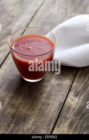 Jus de tomate en verre sur table en bois vintage Banque D'Images