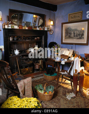 Gamme victorienne en bleu à l'ancienne cuisine avec panier de légumes et de vieilles bottes d'équitation Banque D'Images