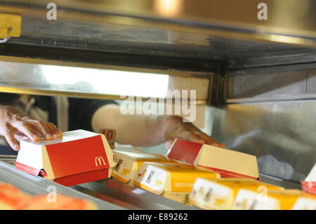 McDonald's le travailleur employé qui travaille dans un fast-food McDonald's restaurant. Banque D'Images