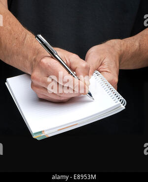 Close-up of a businessman's hand avec un stylo doré écrit quelque chose Banque D'Images