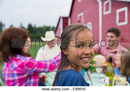 Portrait of Girl enjoying repas de famille à l'extérieur grange