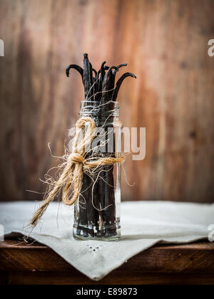 Bâtons de vanille dans un pot sur une table en bois. Banque D'Images