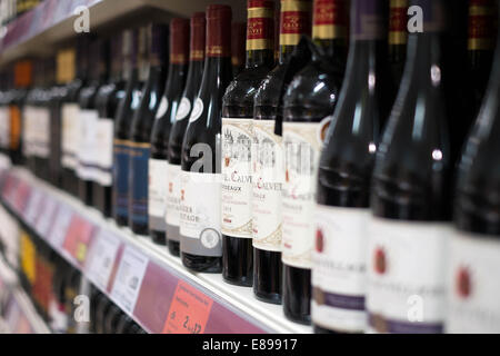 Une sélection de bouteilles de vin rouge sur une étagère dans une succursale de supermarché Sainsbury's affichage des prix & offres Banque D'Images