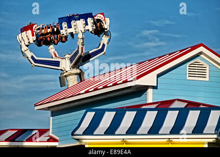 Structures à rayures colorées ainsi que des chasseurs de sensations fortes à l'envers sur le bord de la dernière balade de Casino Pier le 'Super Storm'. Banque D'Images