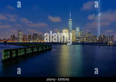 WTC Tribute dans NYC - Lumières sur le 13ème anniversaire, le lower Manhattan skyline encore une fois, rend hommage et se souvient de toutes les victimes de l'horreur des actes terroristes du 11 septembre. Vu, c'est un World Trade Center communément appelée la Tour de la liberté avec les autres gratte-ciel dans le quartier financier et Battery Park article avec les deux faisceaux de lumière brillant à travers un haut ciel nuageux mais très belle soirée. Banque D'Images