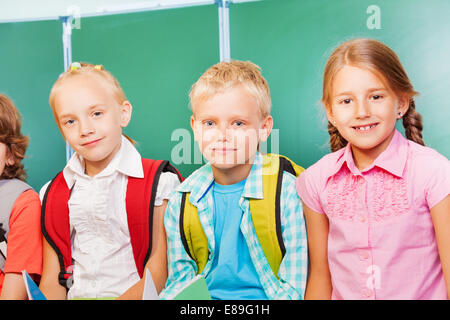 Trois enfants se tenir ensemble in front of blackboard Banque D'Images