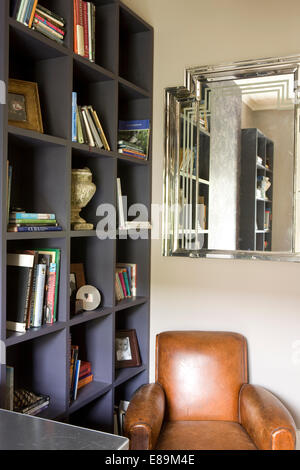 Style Art déco miroir au-dessus de fauteuil en cuir à l'angle de l'étude moderne peint avec étalage Banque D'Images