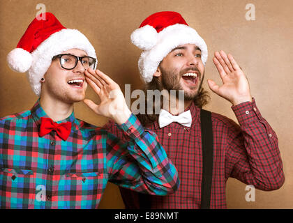 Deux mecs en vêtements hippie du Père Noël dans un cri de Noël Banque D'Images