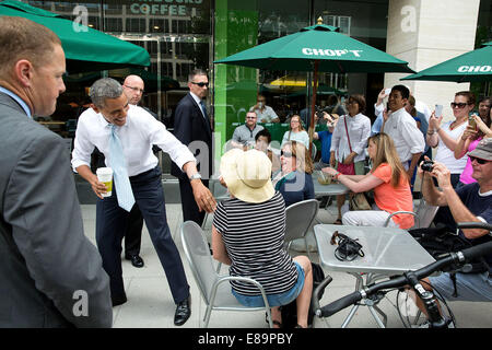 Le président américain Barack Obama salue des gens assis à l'extérieur d'un Chop't restaurant après la suppression par un Starbucks sur Pennsylvania Avenue à Washington, D.C., 9 juin 2014. Banque D'Images