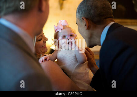 Le président américain Barack Obama salue Zoe Mahan, fille de Hunter Mahan et Kandi, lors d'une réception pour la Coupe du Président 2013 les équipes de golf de championnat dans la salle bleue de la Maison Blanche, 24 juin 2014. Banque D'Images