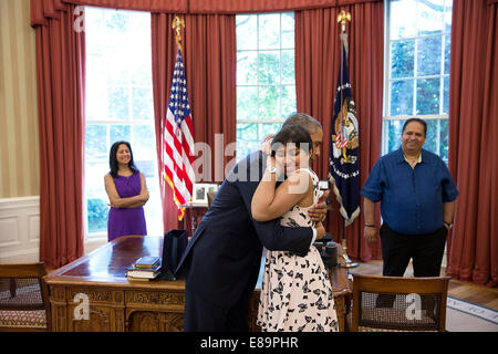 Le président Barack Obama hugs Mohini Samani, un 16-year-old Make-A-Wish bénéficiaire de Smethwick, en Angleterre, dans le bureau ovale, le 26 juin 2014. Les parents de Mohini Urvashi Radia et Nimesh Radia accompagner. Banque D'Images