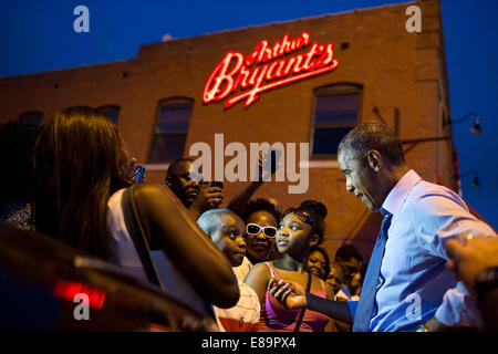 Le président américain Barack Obama salue la foule à l'extérieur de Arthur Bryant's Barbeque après avoir dîner avec des personnes qui avaient écrit des lettres à lui, à Kansas City, Mo., 29 juillet 2014. Banque D'Images