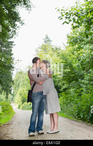 Mature couple kissing in forest Banque D'Images