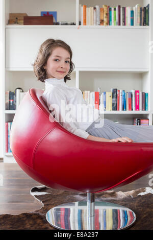 Portrait of Girl sitting on chair, smiling Banque D'Images