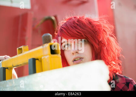 Jeune adolescente piercings cheveux teints en rouge Banque D'Images