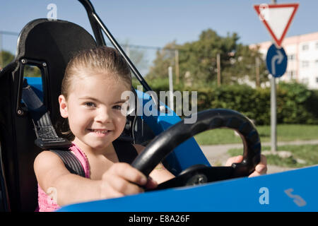 Smiling girl in véhicule sur la zone de formation de conducteur Banque D'Images