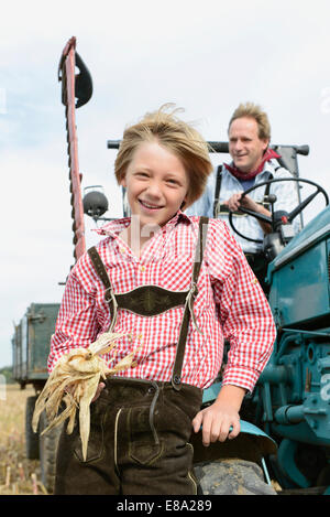 Père et fils avec le tracteur dans un champ, Bavière, Allemagne Banque D'Images