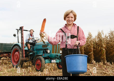 Père et fils sur le tracteur dans un champ, Bavière, Allemagne Banque D'Images