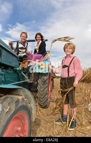 La famille sur le tracteur dans un champ, Bavière, Allemagne Banque D'Images