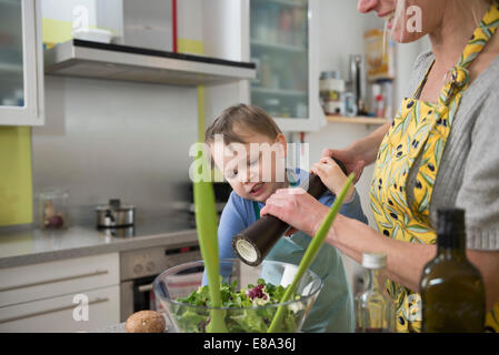 Boy aider sa mère à salade Banque D'Images