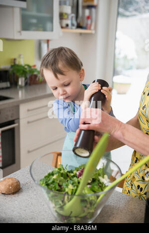 Boy aider sa mère à salade Banque D'Images
